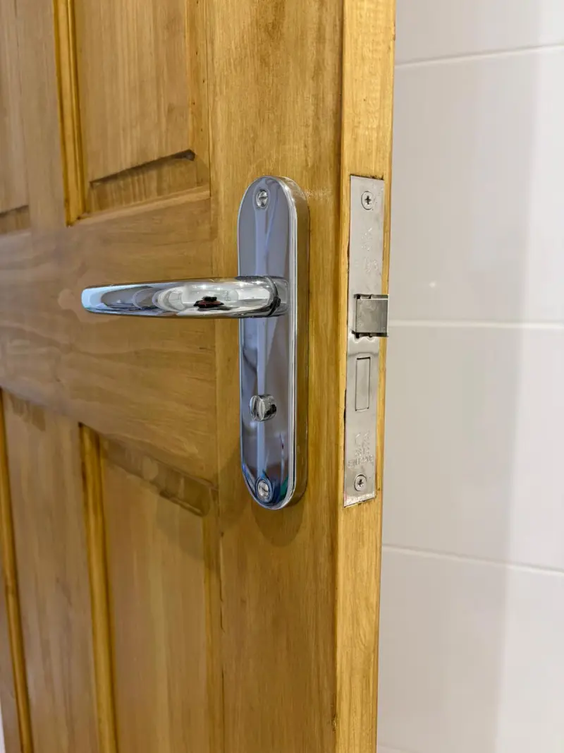 Refurbished oak internal door with fresh varnish, new chrome handle and lock installation.