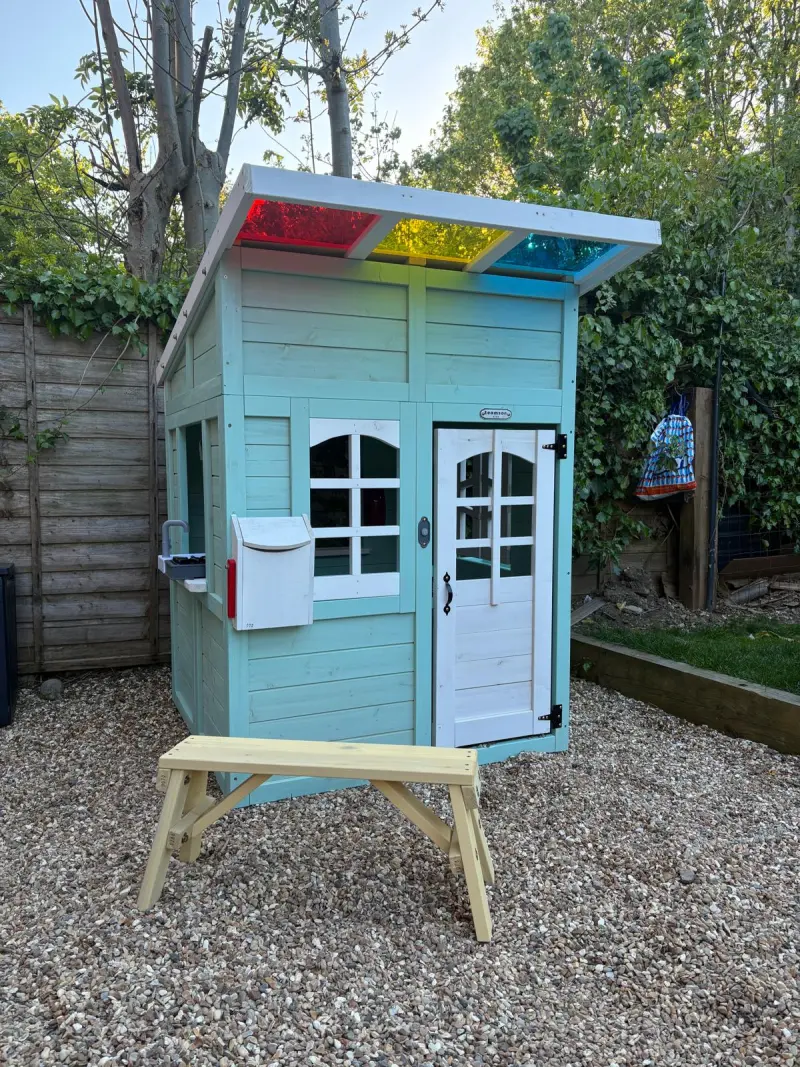 Children's wooden playhouse assembled by Boreham Wood Handyman with coloured roof panels and opening doors.